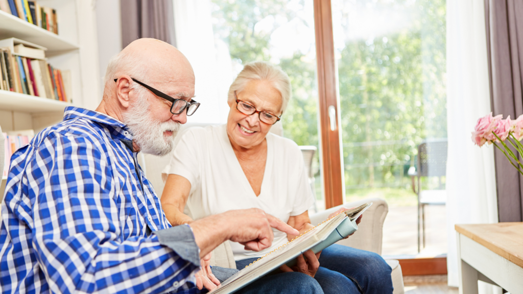 Older couple looking at photo album together to illustrate an example of living well after a dementia diagnosis
