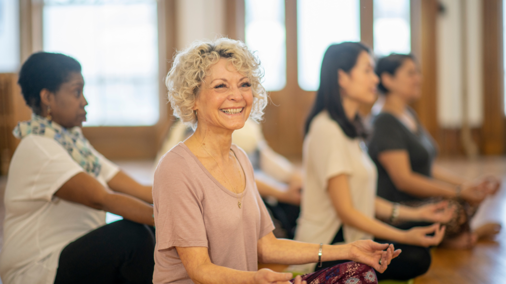 Woman taking part in yoga class - yoga can be adapted to be one of many fantastic dementia activities for every stage
