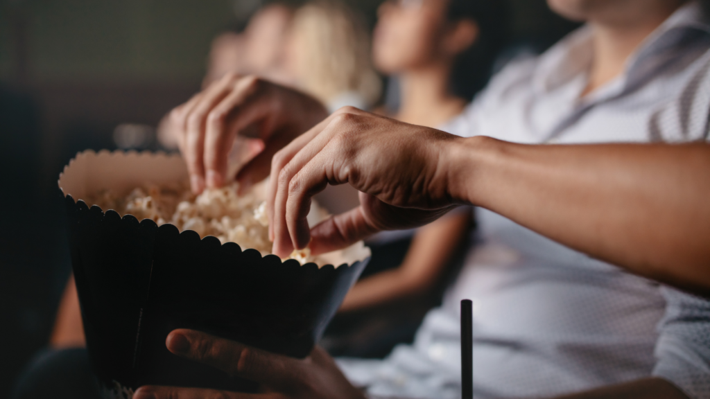 People eating popcorn at a cinema - cinemas offer inclusive screenings which are dementia friendly