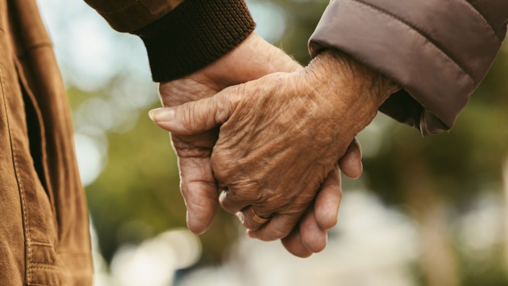 older couple holding hands on a day out to boost mental health and identity for people with dementia