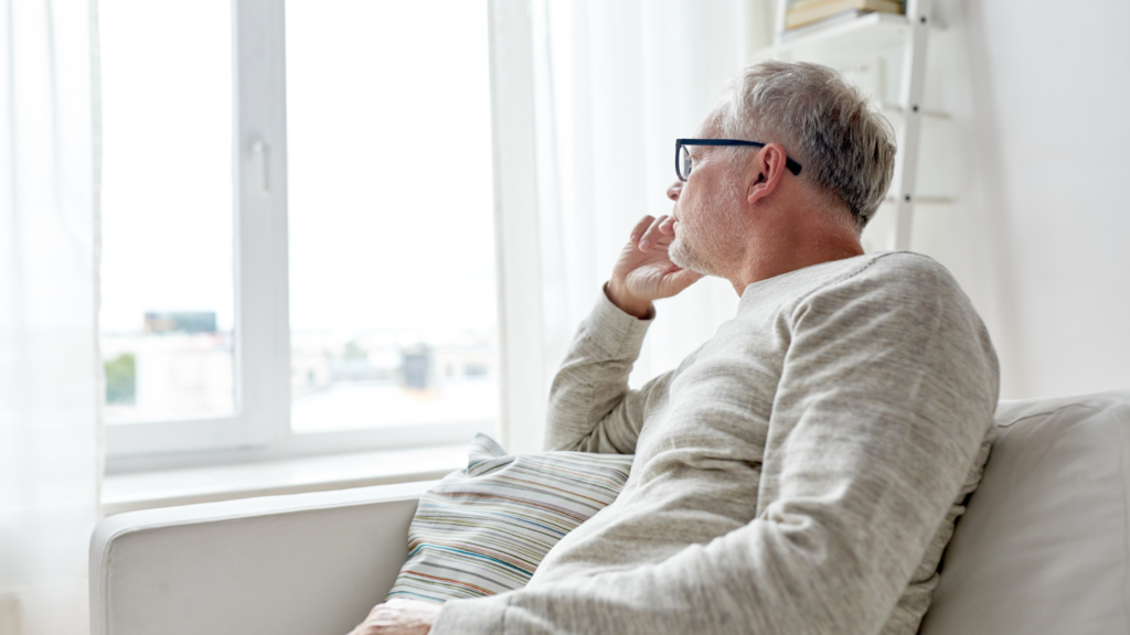 man staring out of window
