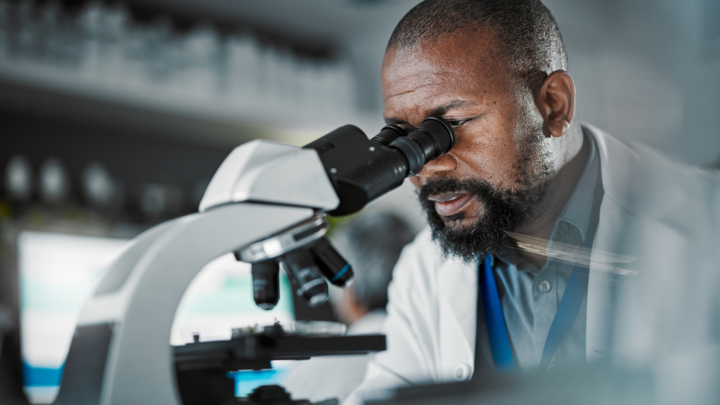scientist in lab coat with microscope to illustrate scientific impact of dementia on the brain