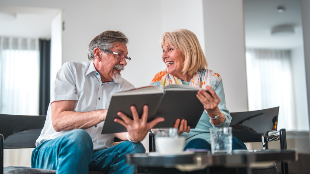 older couple looking at a photo album together to demonstrate the benefits of reminiscence therapy for people with dementia