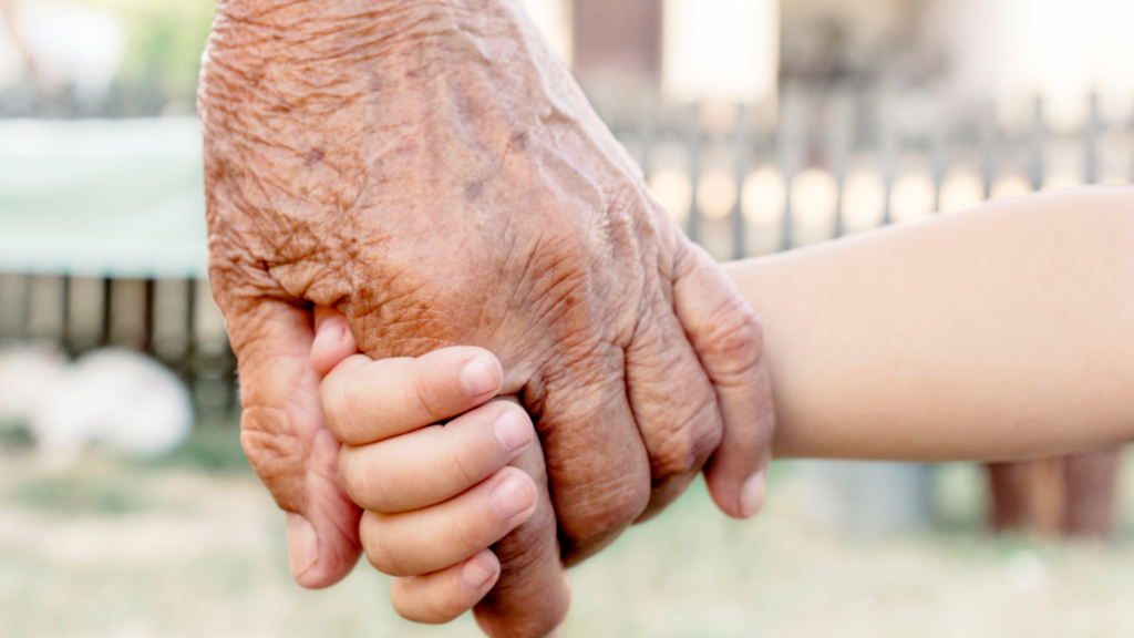 child holding hands with grandparent on the subject of whether dementia is passed down from parents and grandparents - exploring the connection between genes and dementia