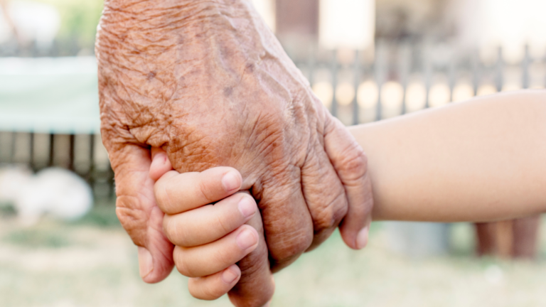 child holding hands with grandparent on the subject of whether dementia is passed down from parents and grandparents - exploring the connection between genes and dementia