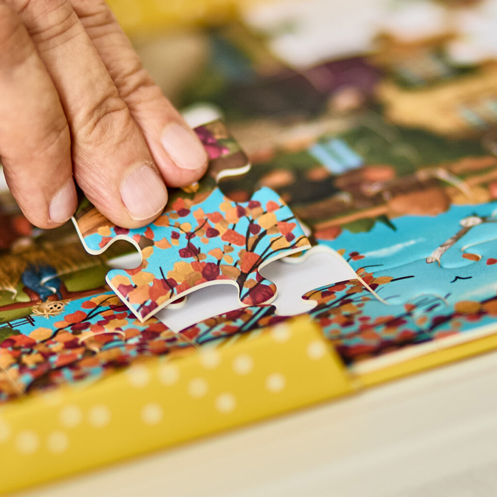 Hand placing an extra large puzzle piece in a puzzle